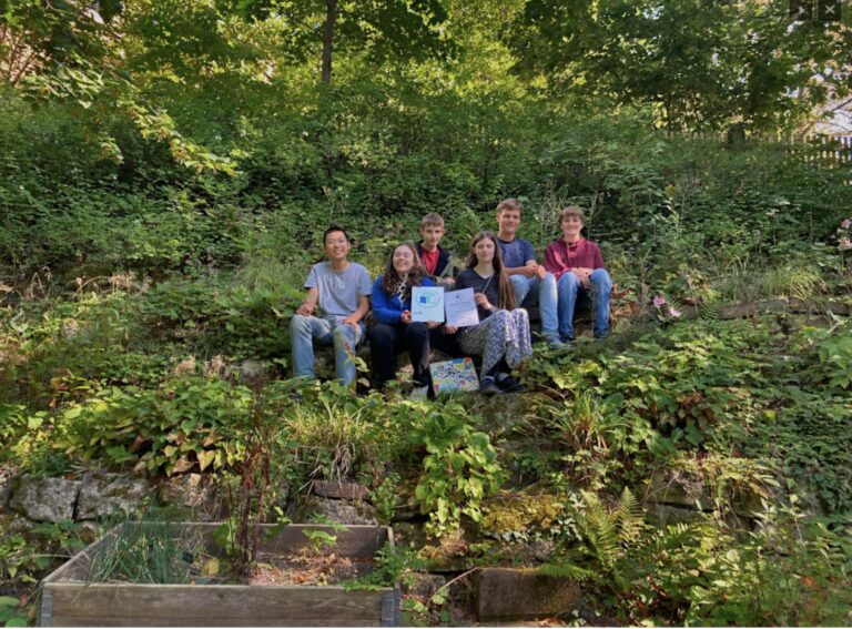 Schülergruppe im Schulgarten mit Urkunde